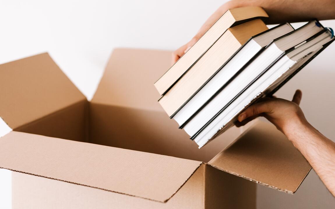 Boeken in een kartonnen doos leggen