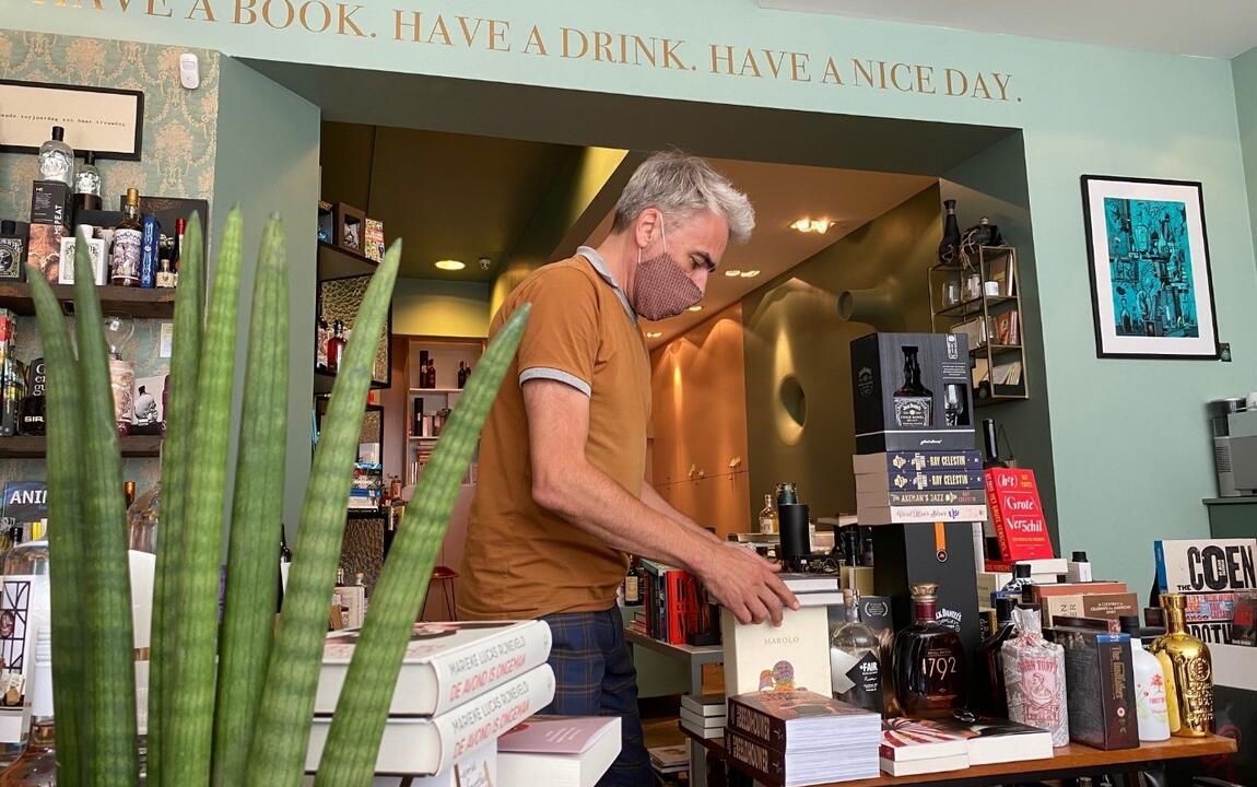 Man in boekenwinkel bladert door boek