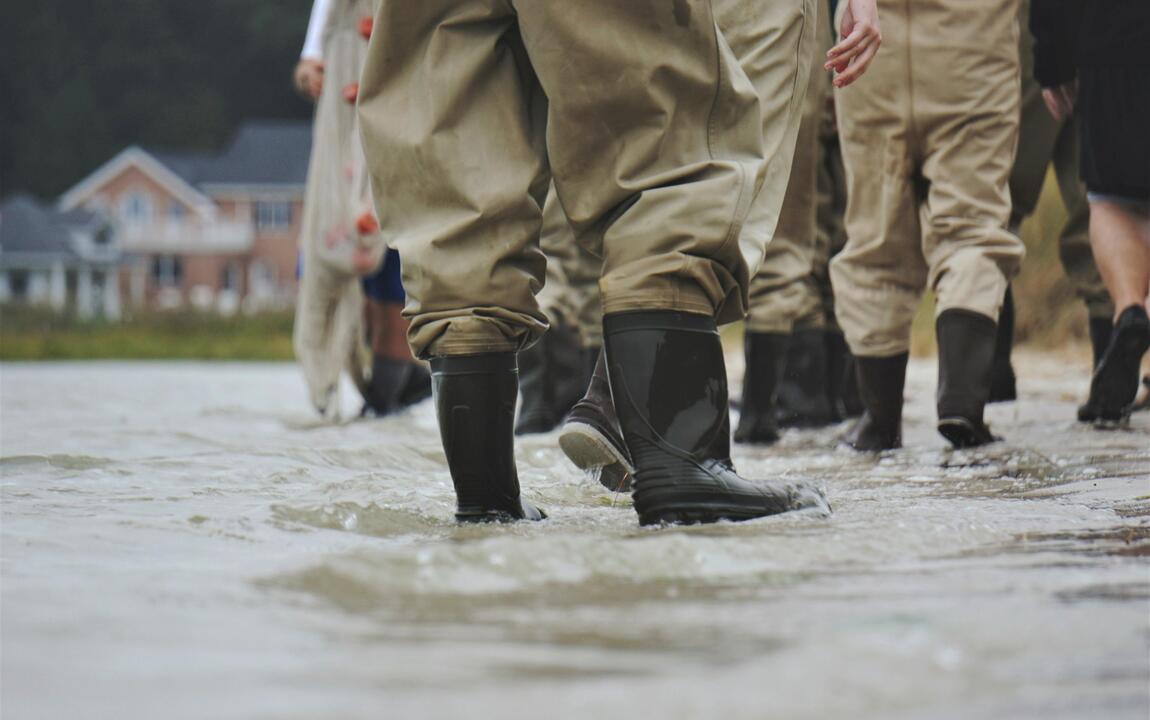 Mensen met laarzen in hoogstaand water