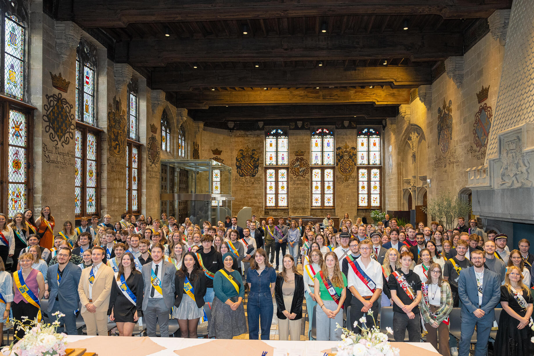 Praesidiumleden van studentenverenigingen poseren met hun studentenlint voor een groepsfoto in het stadhuis