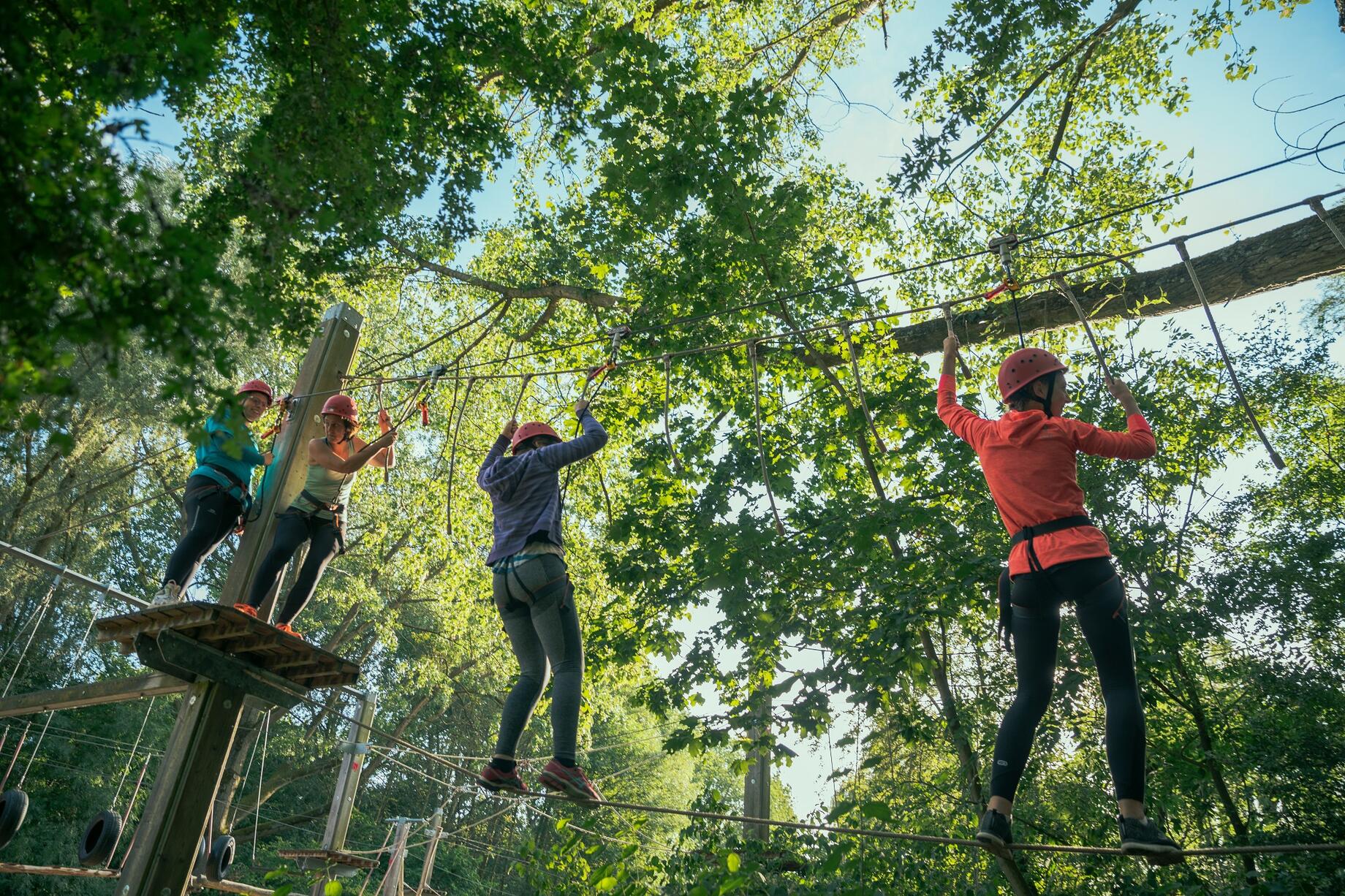 Mensen die in de touwen hangen op het hoogteparcours